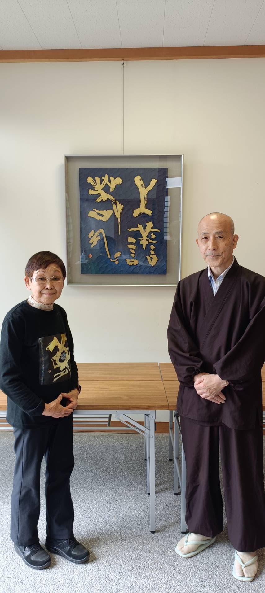 伝心寺住職と刻字作品『上善若水』の前に立つ安齋佳子