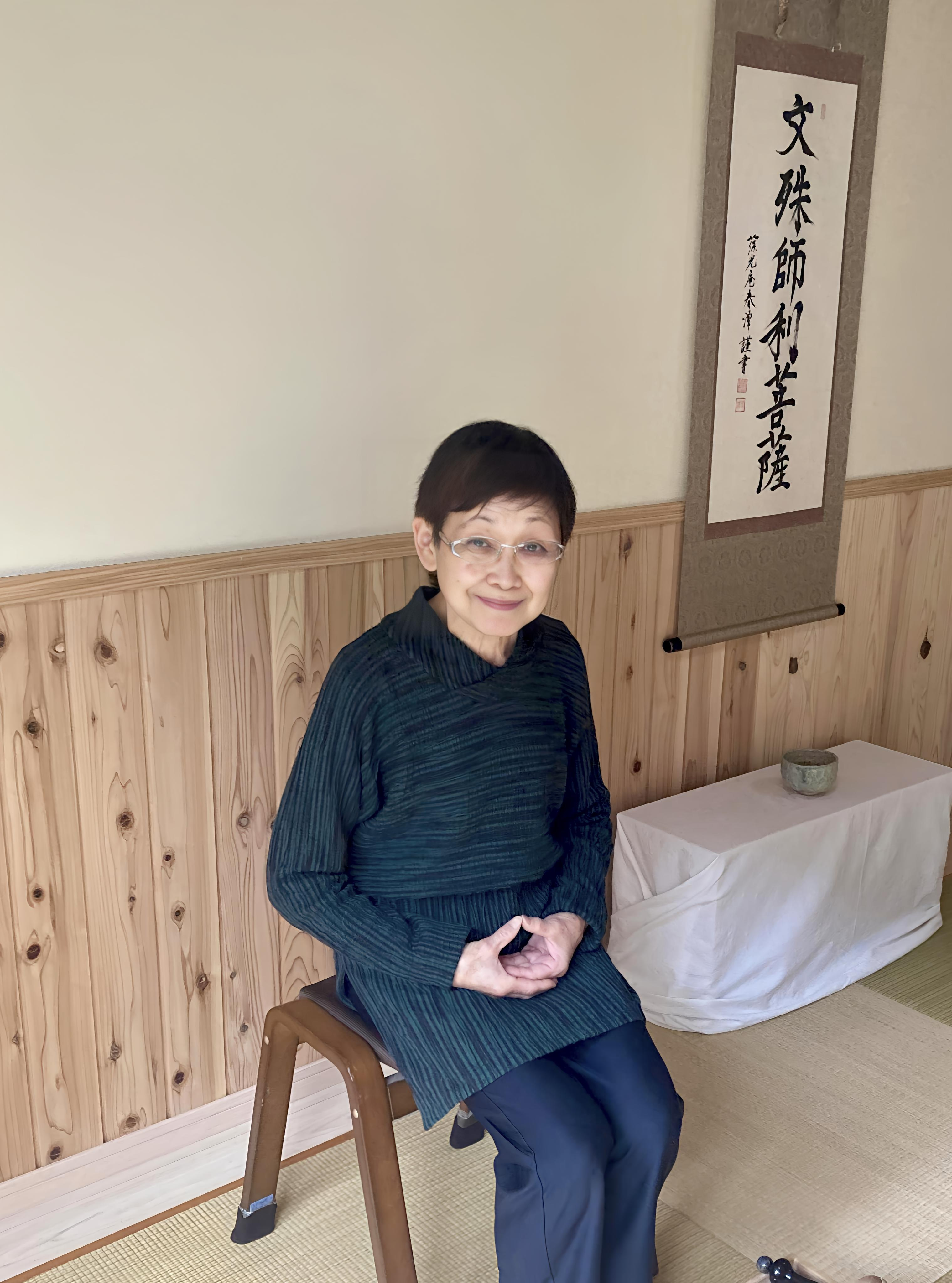 書作品の前に座る刻字作家・安齋佳子
